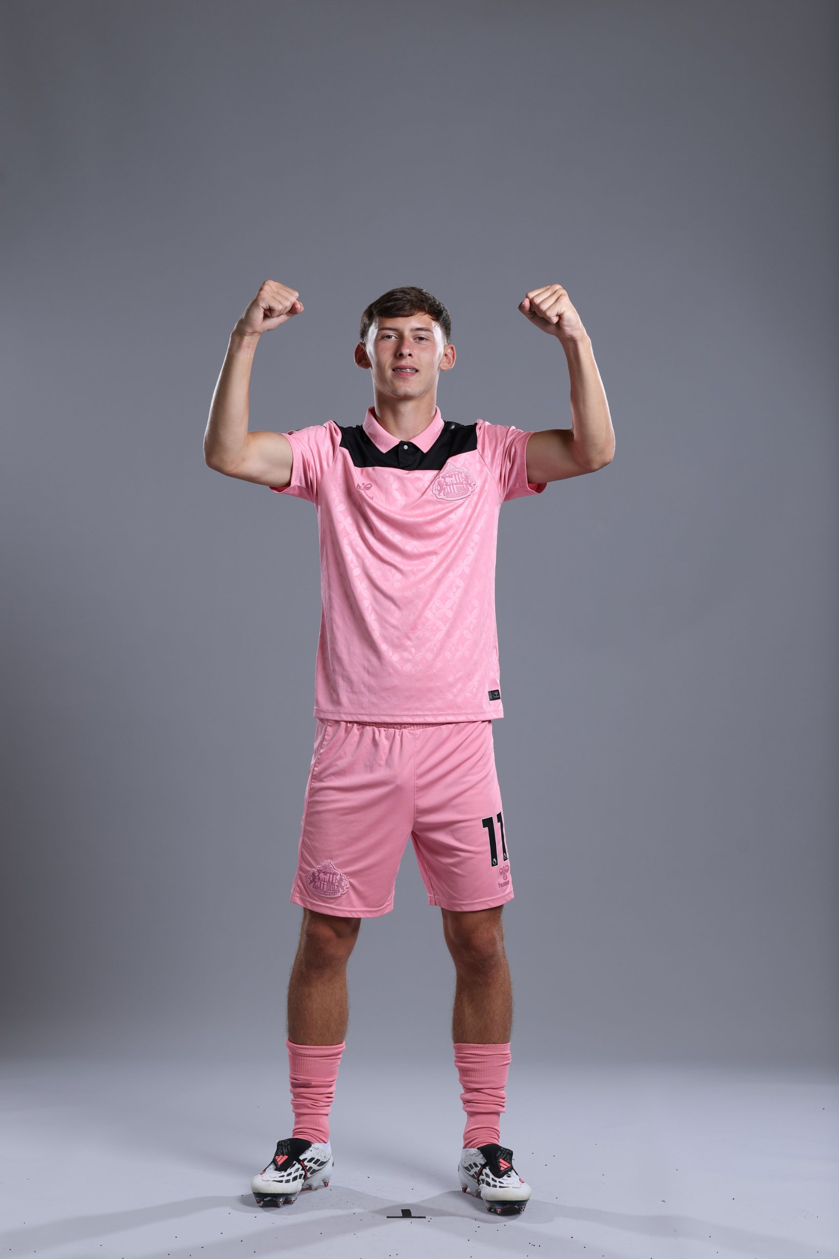 Chris Rigg in the pink kit, arms raised in celebration